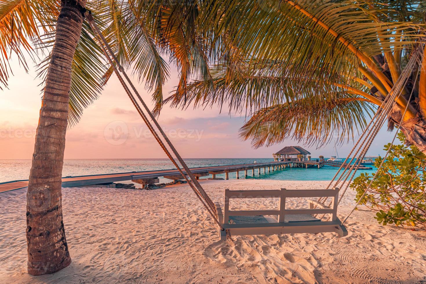 romantico coppia swing vicino per calma mare e tropicale isole costa. esotico Paradiso spiaggia paesaggio, palma alberi, tramonto cielo e estate paesaggio Visualizza. Maldive molo, acqua villa foto