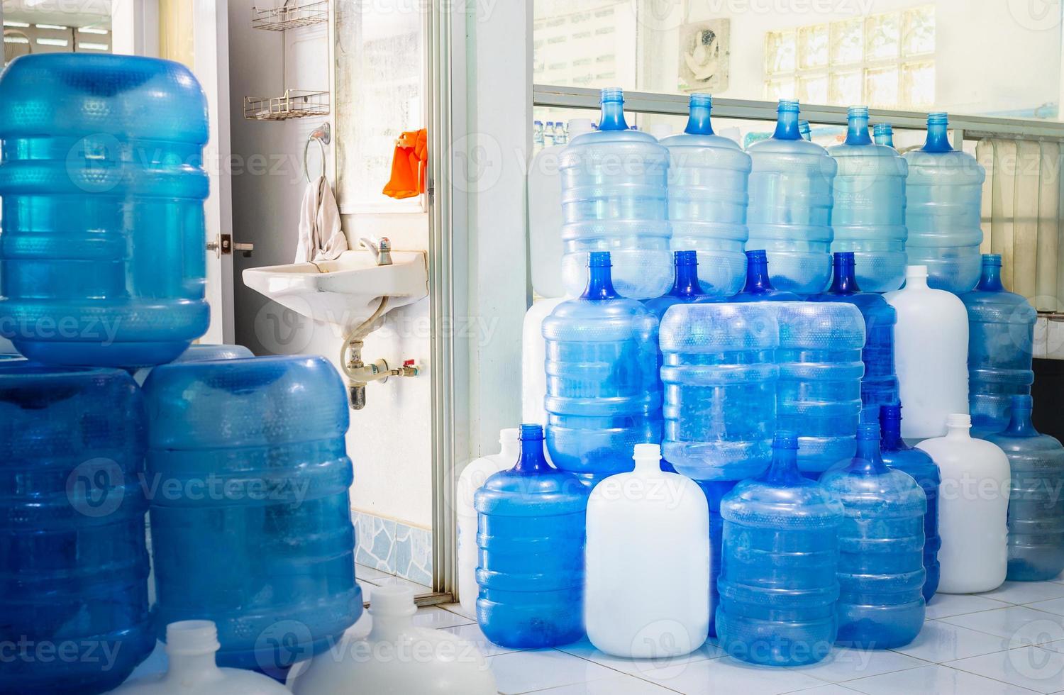 blu plastica bottiglie o blu galloni di potabile acqua siamo impilati nel il potabile acqua fabbrica per ciclo il potabile acqua.acqua fabbrica attività commerciale concetto foto