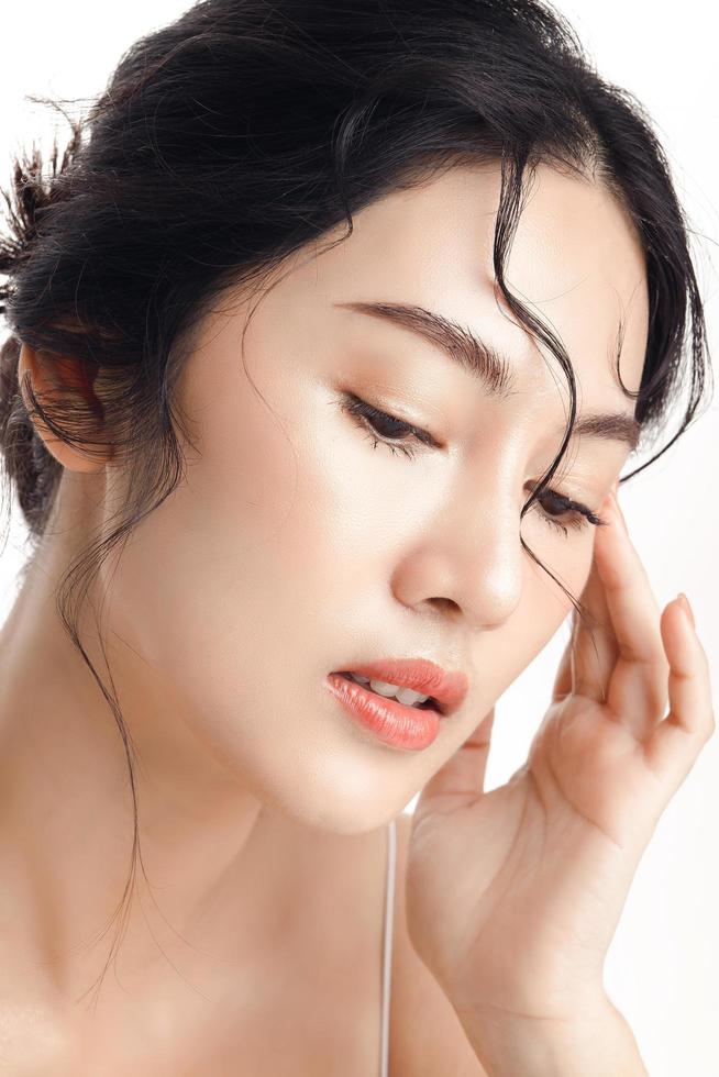 asiatico donna con un' bellissimo viso e Perfetto pulito fresco pelle. carino femmina modello con naturale trucco e scintillante occhi su bianca isolato sfondo. facciale trattamento, cosmetologia, bellezza concetto. foto