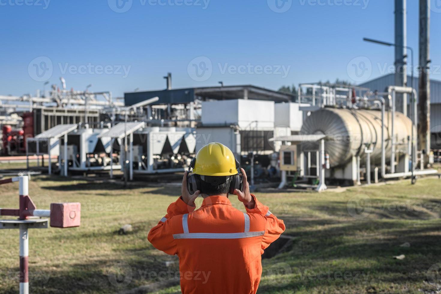 gas lavoratori indossare paraorecchie per opera nel olio raffinerie foto