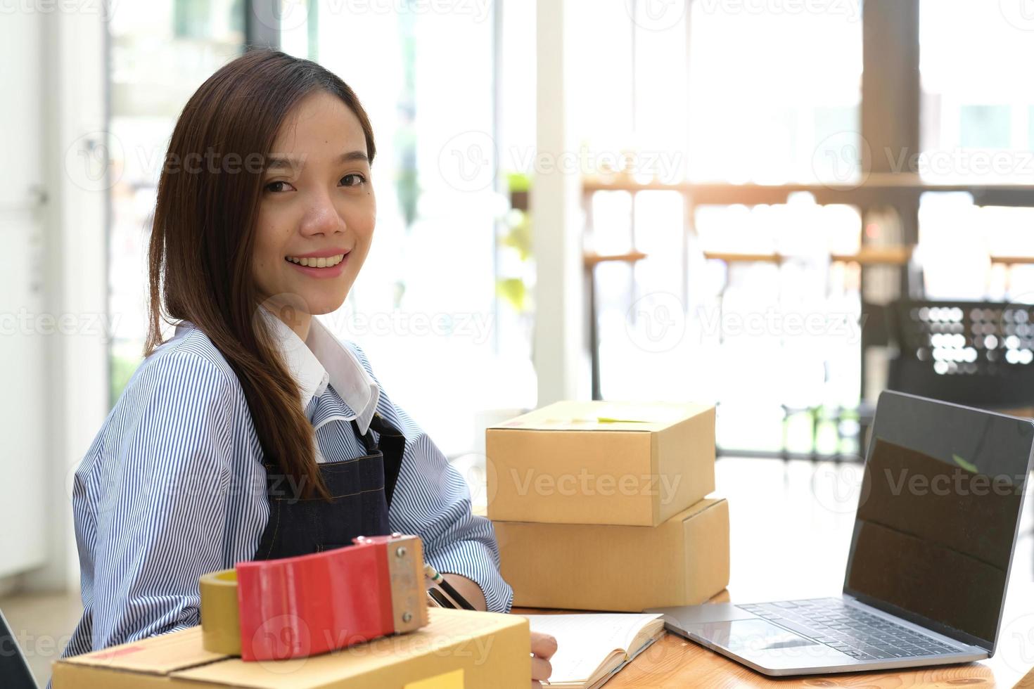 ritratto di giovane donna asiatica sme che lavora con una scatola a casa sul posto di lavoro. proprietario di una piccola impresa di start-up, PMI imprenditore di piccole imprese o business freelance online e concetto di consegna. foto