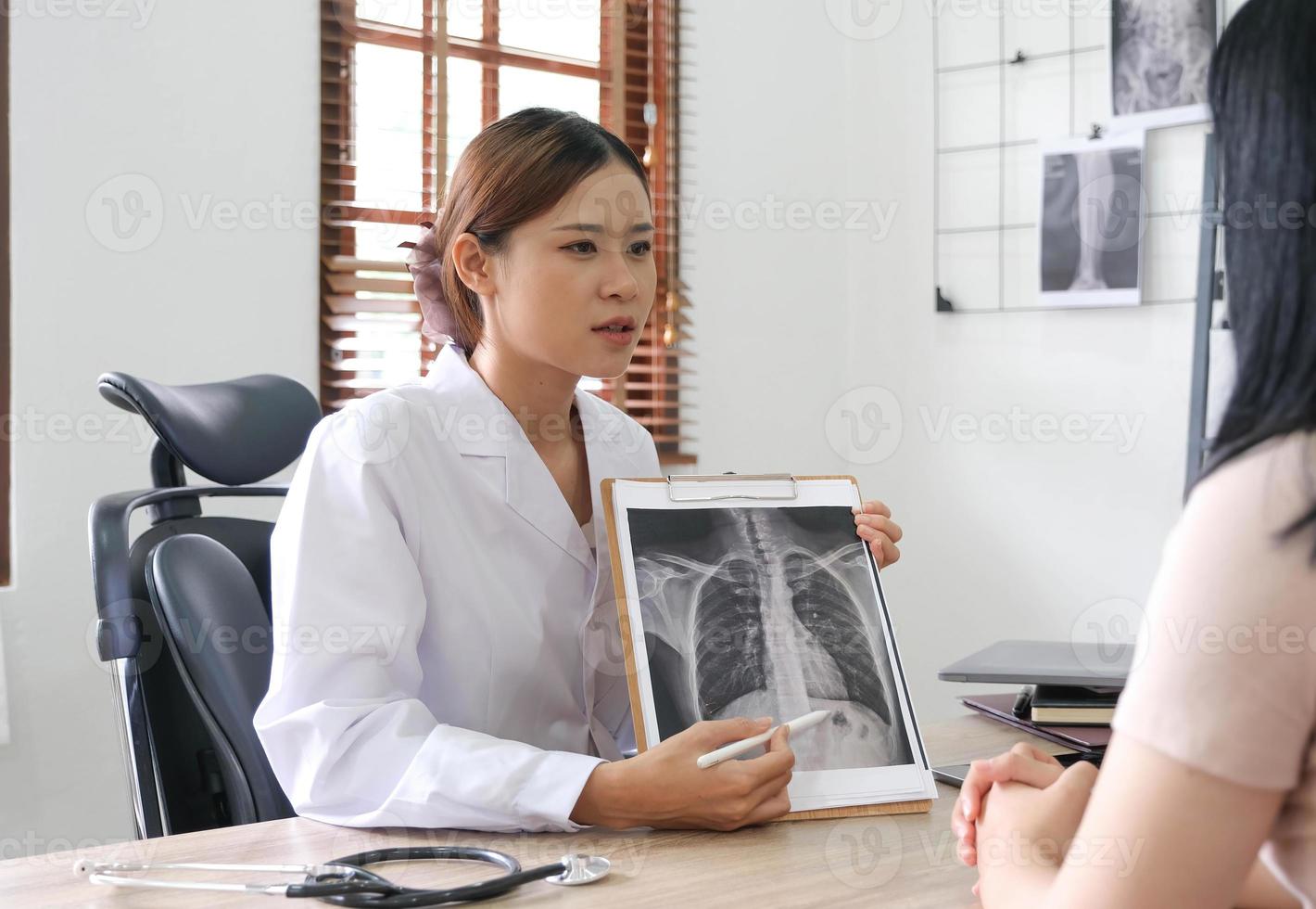 medico mostrando raggi X risultato per paziente nel clinica. foto