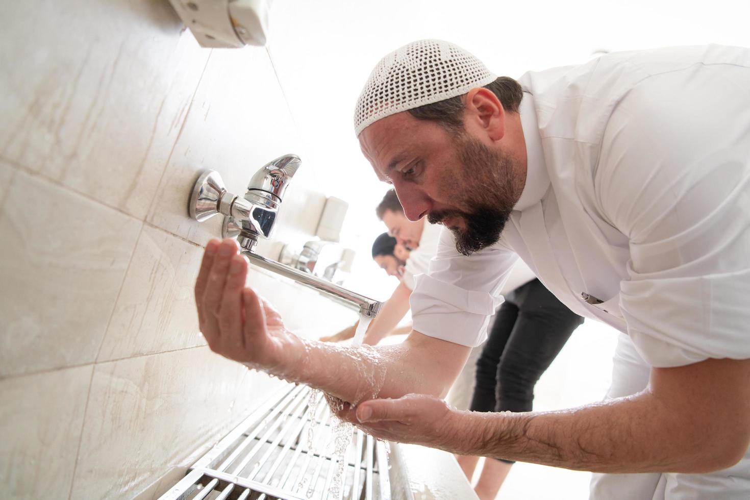 un' gruppo di I musulmani prendere abluzione per preghiera. islamico religioso rito foto