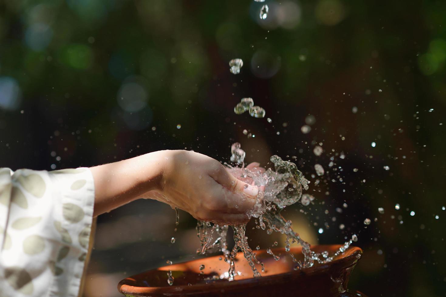 spruzzi fresco acqua su donna mani foto