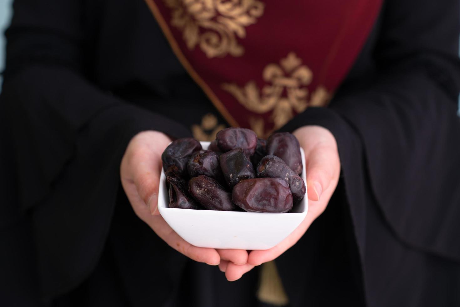 moderno musulmano donna Tenere un' piatto di date nel Ramadan kareem foto