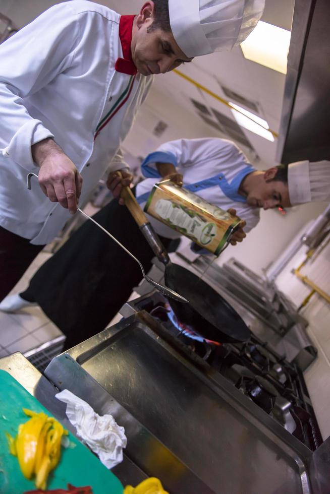 capocuoco preparazione cibo, frittura nel wok padella foto