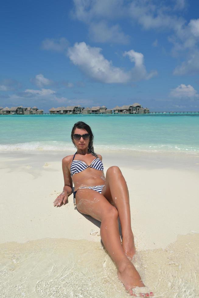 bellissimo giovane donna su spiaggia avere divertimento e rilassare foto