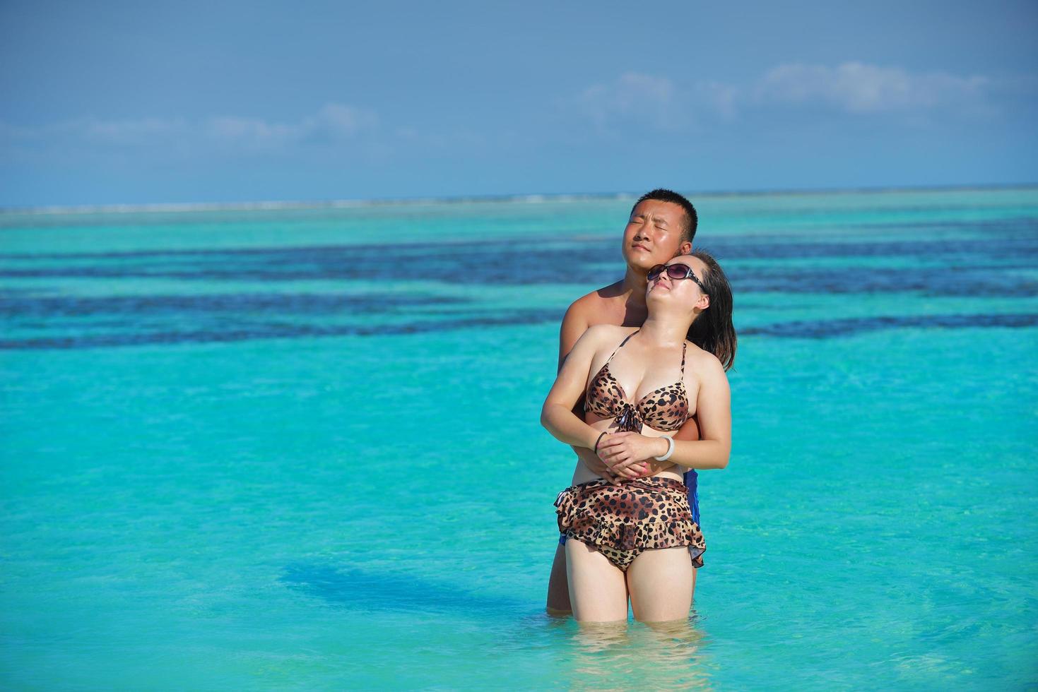 contento giovane coppia godendo estate su spiaggia foto