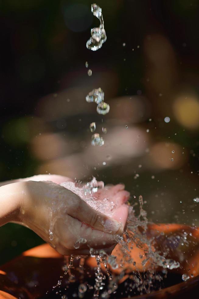 spruzzi fresco acqua su donna mani foto