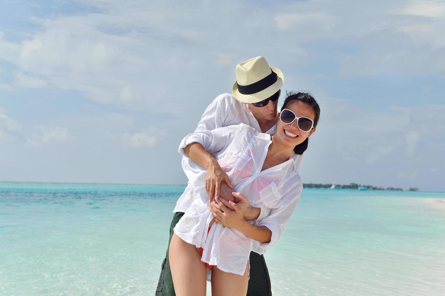 la giovane coppia felice si diverte sulla spiaggia foto