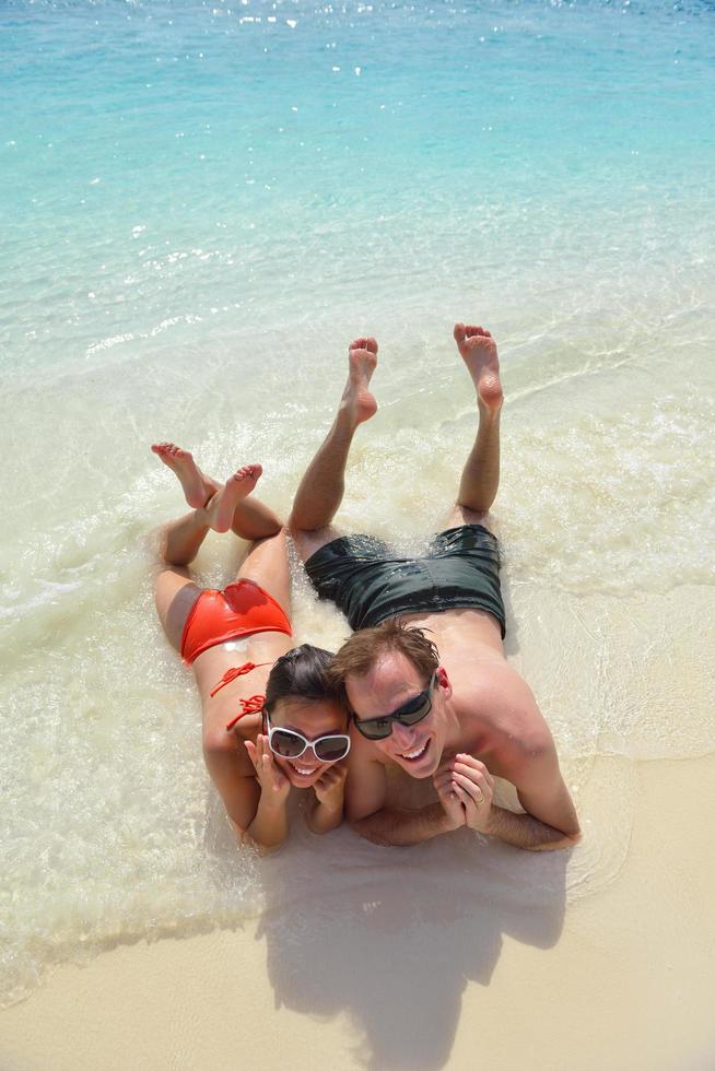 la giovane coppia felice si diverte sulla spiaggia foto