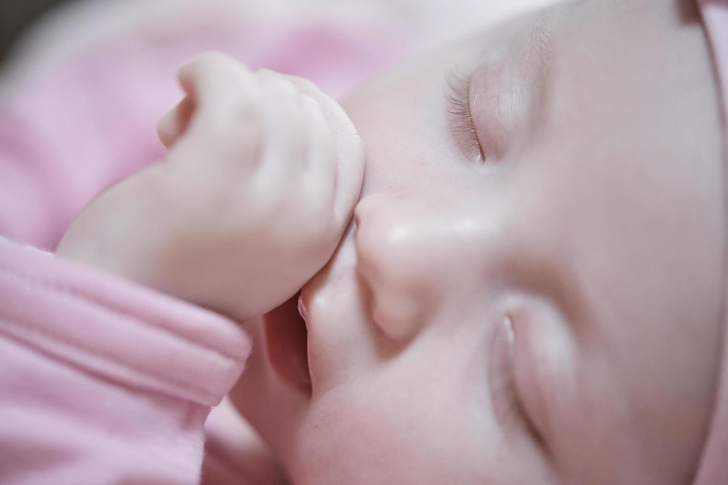 neonato bambino addormentato a casa nel letto foto