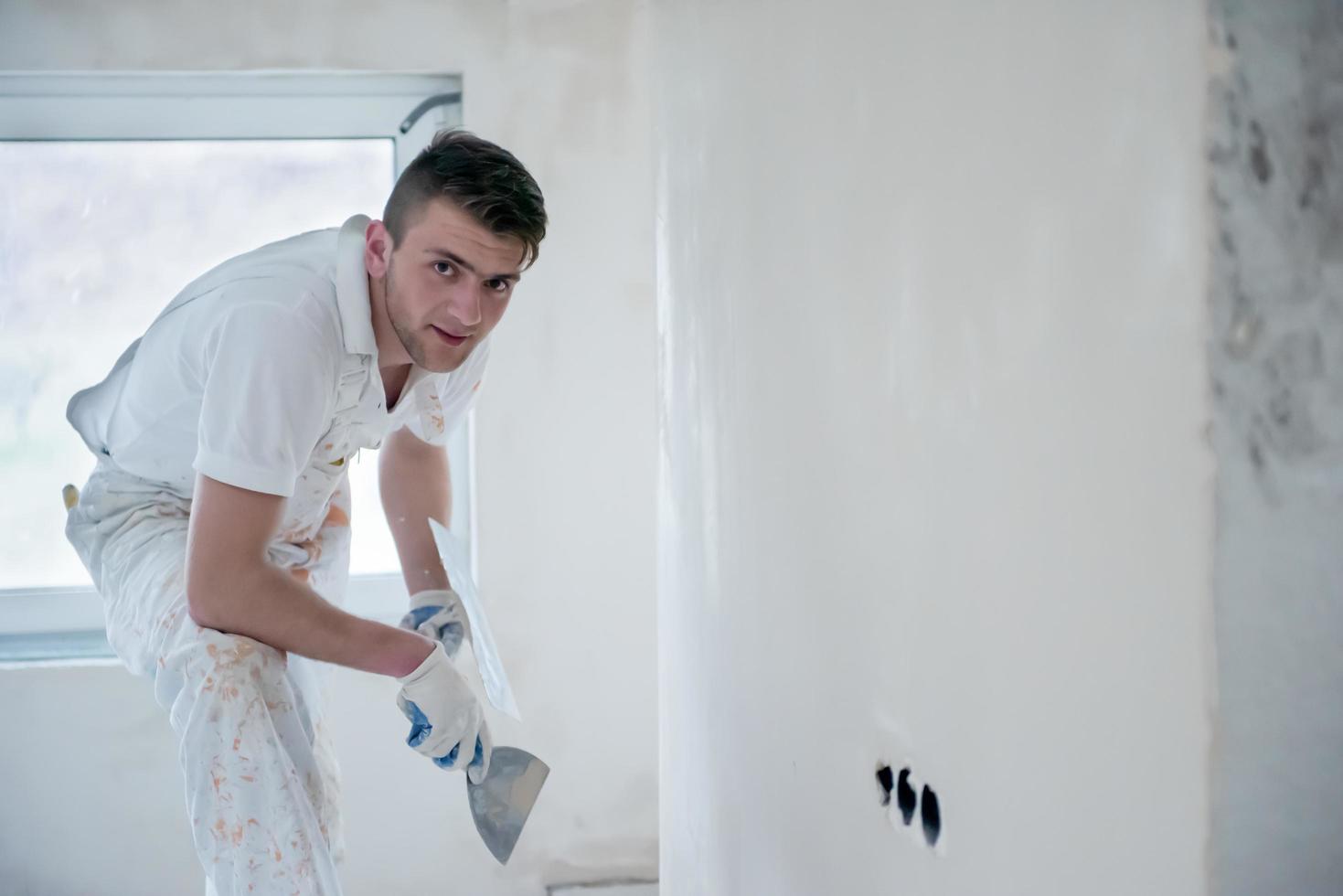 costruzione lavoratore intonacatura su gesso muri foto