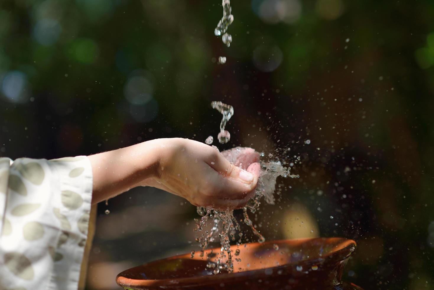 spruzzi fresco acqua su donna mani foto