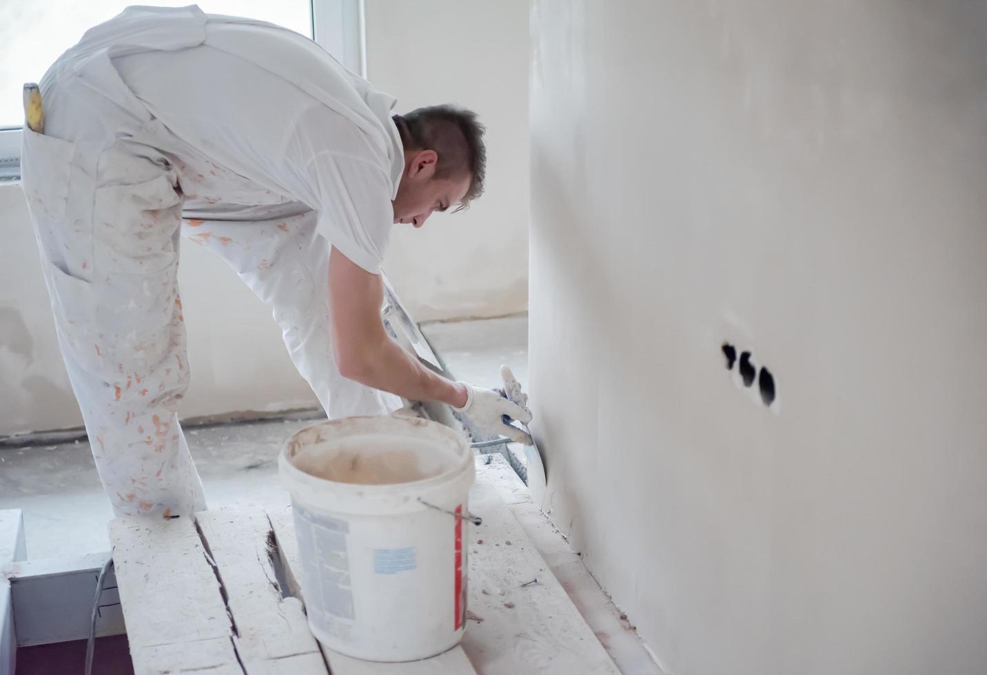 costruzione lavoratore intonacatura su gesso muri foto