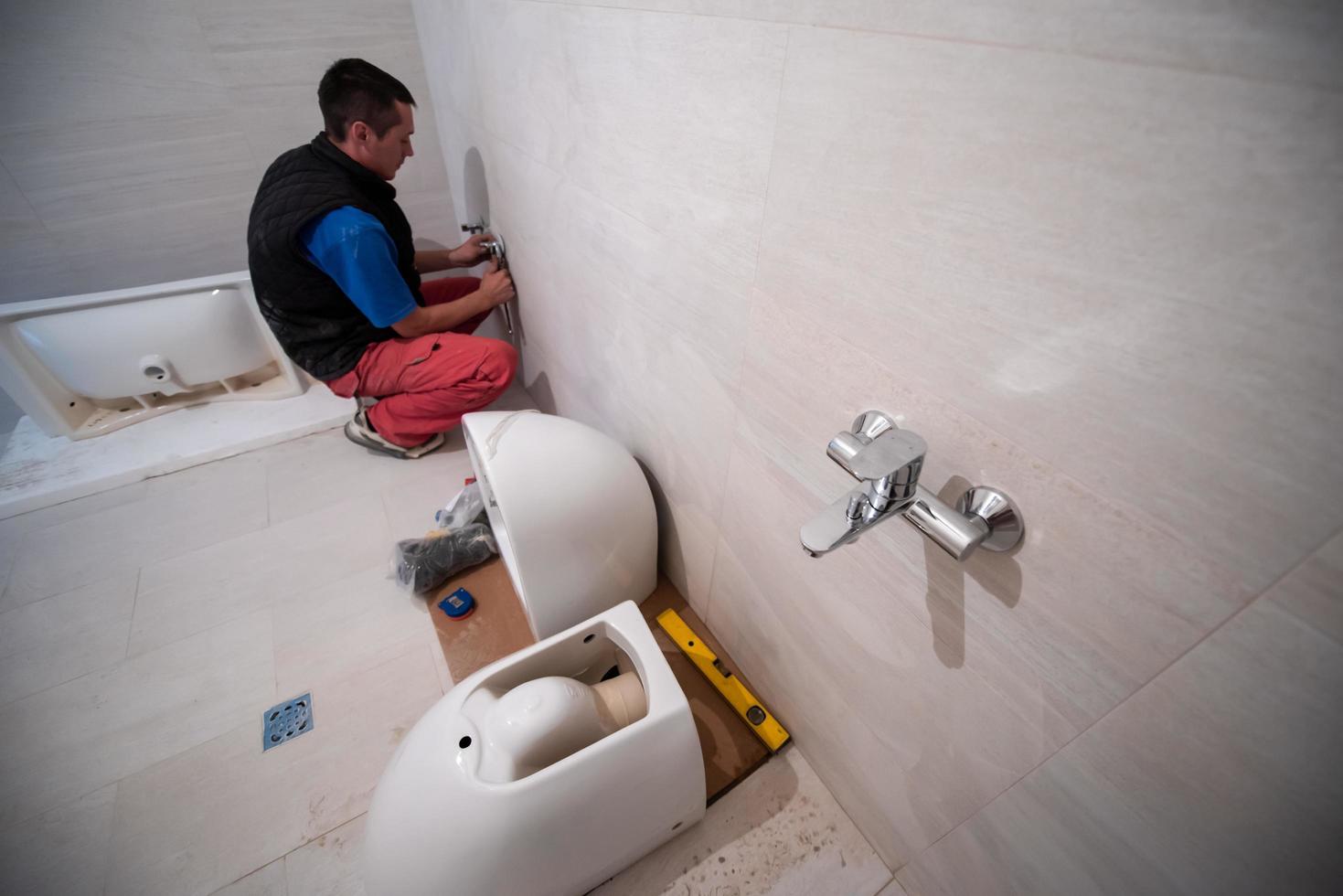 professionale idraulico Lavorando nel un' bagno foto