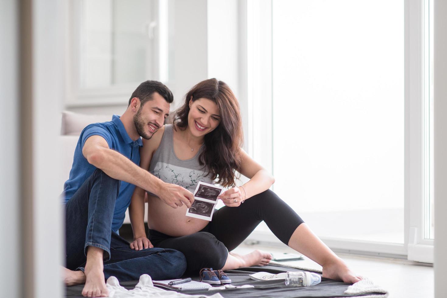 incinta coppia controllo un' elenco di cose per loro nascituro bambino foto