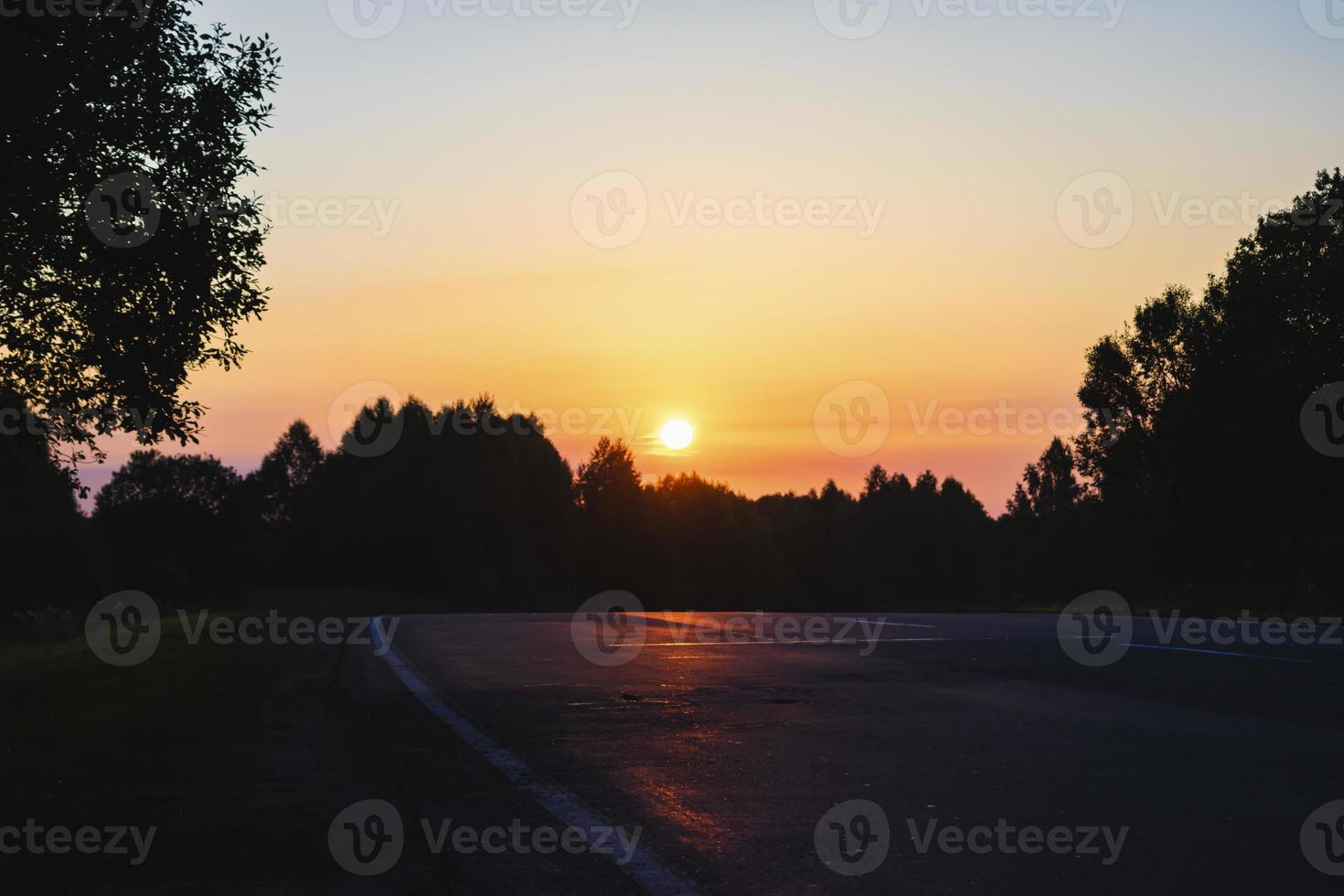 alba al di sopra di il strada principale in direzione il buio foresta foto