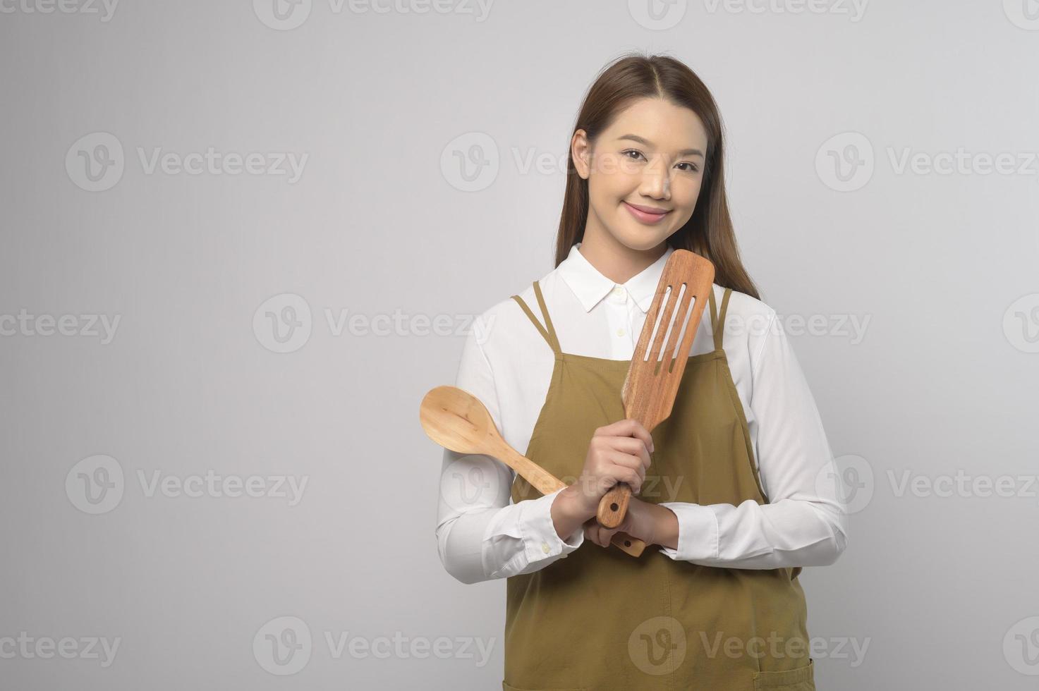 ritratto di giovane asiatico donna indossare grembiule al di sopra di bianca sfondo studio, cucinando e imprenditore concetto foto