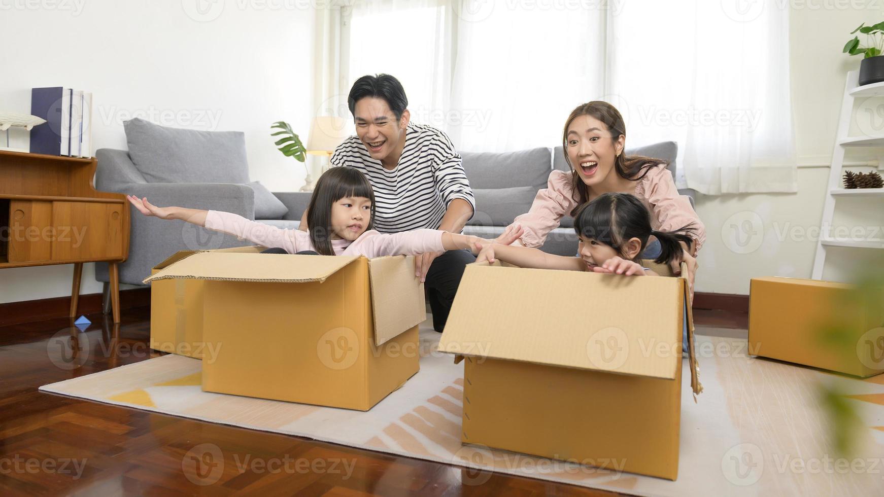 asiatico famiglia marito e moglie e bambini con cartone scatole avendo divertimento su in movimento giorno, mutuo, prestito, proprietà e assicurazione concetto. foto