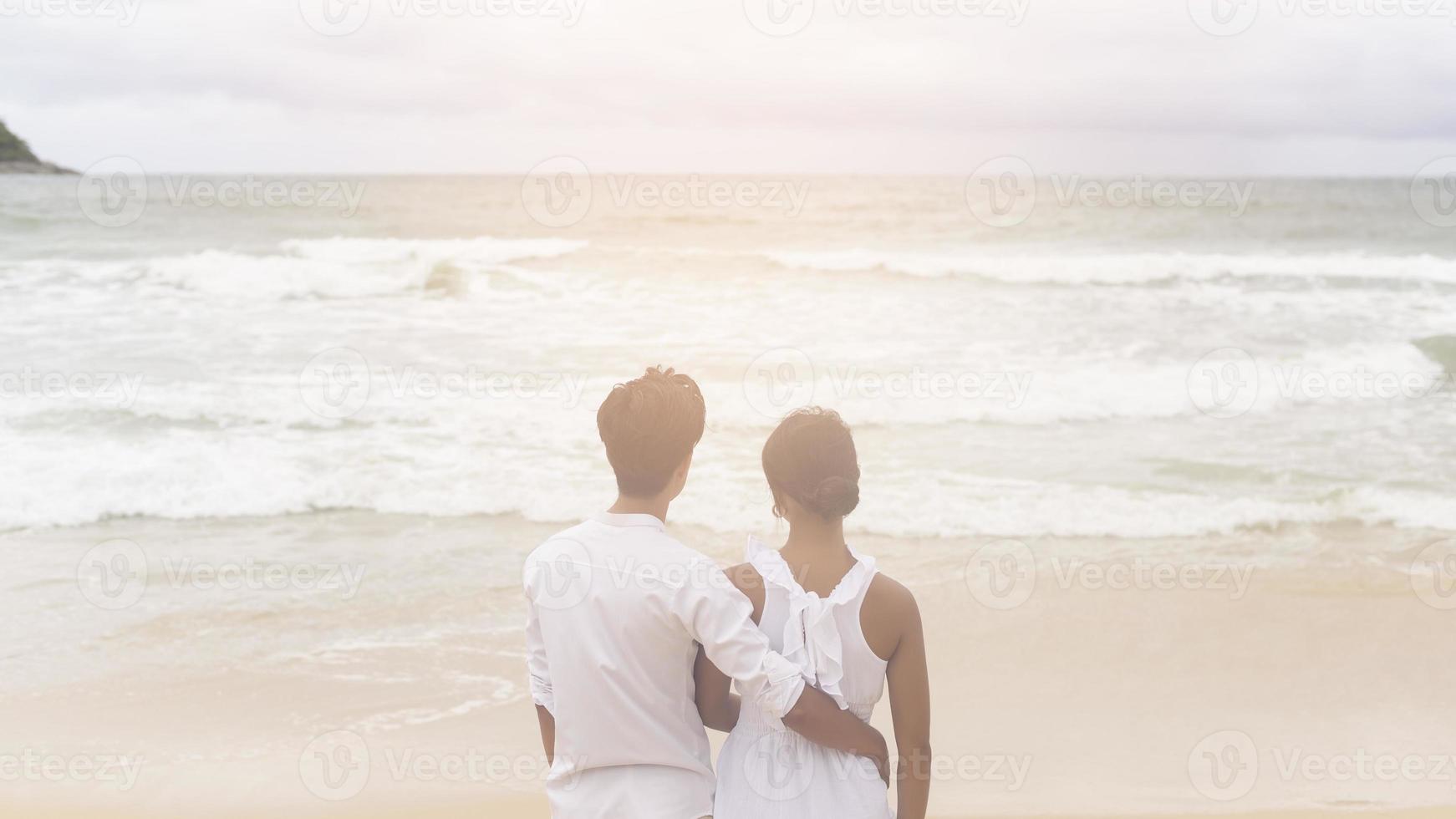 contento giovane coppia indossare bianca vestito su il spiaggia su vacanze, viaggiare, romantico, nozze concetto foto