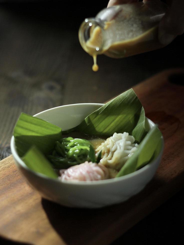 Vista ad alto angolo del piatto tramoggia di stringa betawi indonesiano chiamato putu mayang cake, con noodles a forma di forma, servito w foto