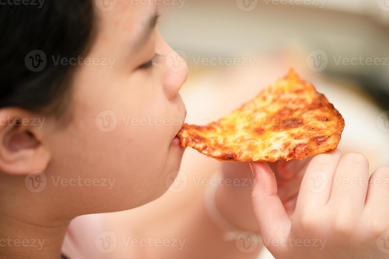 il bambino mangia la pizza foto