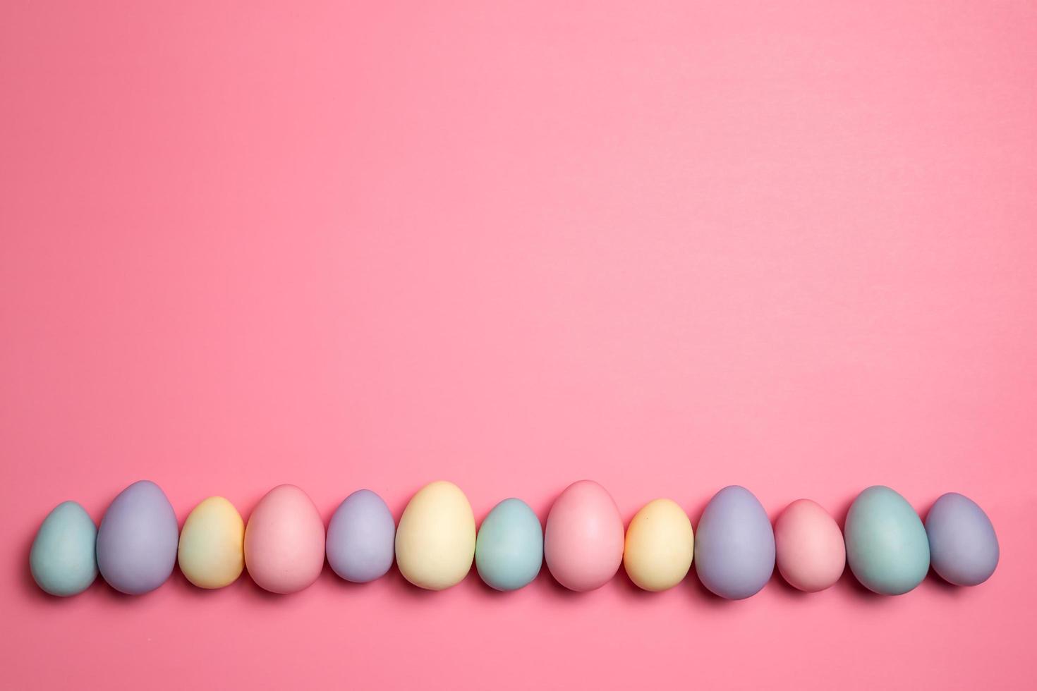 riga di pastello colorato Pasqua uova su un' rosa sfondo foto