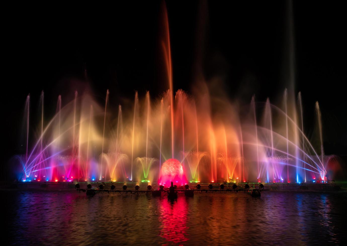 la fontana colorata che balla per celebrare l'anno con sfondo scuro del cielo notturno. foto