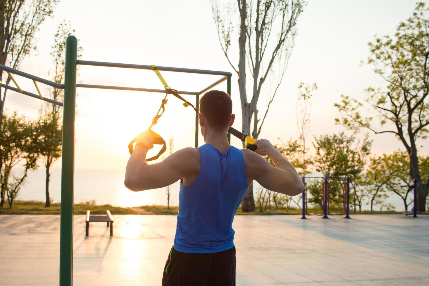 fit allenamento maschile in estate, esercizi con cinghie di sospensione all'aperto foto