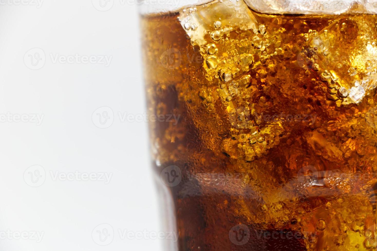 cola vetro con schiacciato su uno sfondo bianco cola ghiaccio in vetro e ci sono goccioline d'acqua intorno. bevanda fresca nera fresca. foto