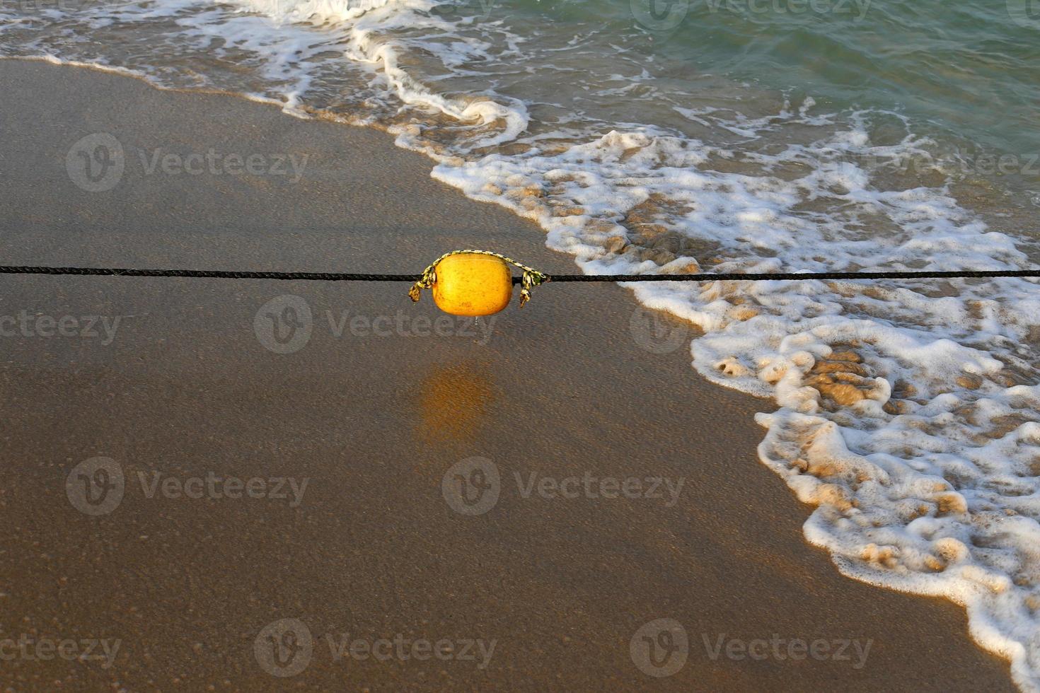 una corda con galleggianti per assicurare una zona sicura di balneazione sulla spiaggia. foto