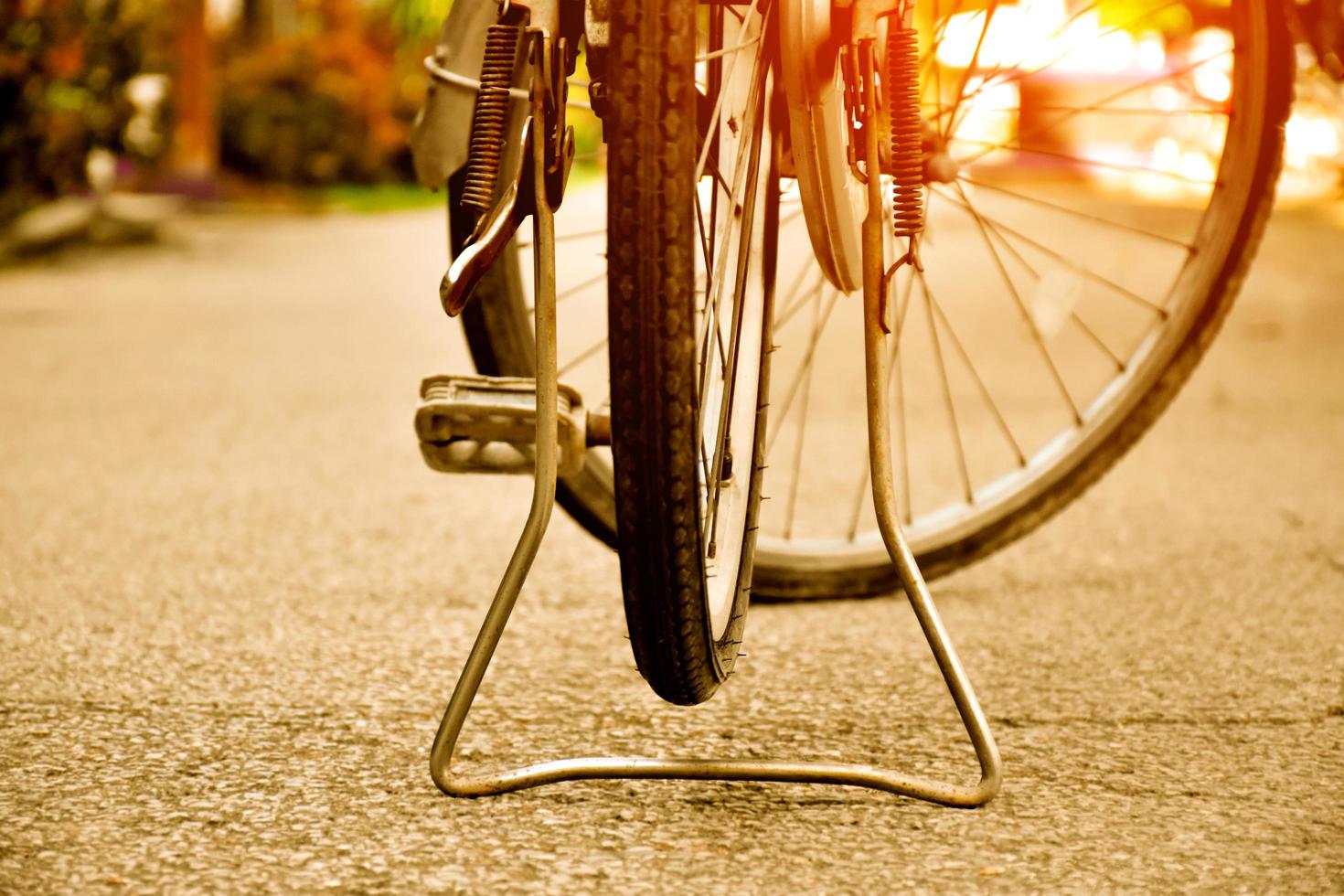 avvicinamento Visualizza di posteriore piatto pneumatico di Vintage ▾ bicicletta quale parcheggiata su marciapiede accanto il strada. morbido e selettivo messa a fuoco. foto