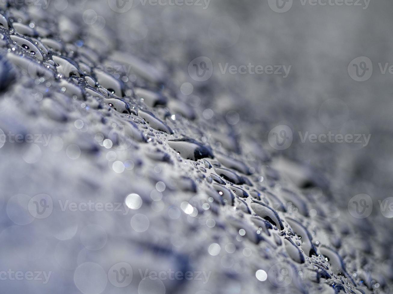 pioggia gocce su blu metallo vicino su macro foto