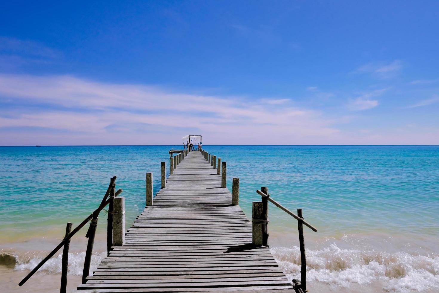 un molo di legno che si protende verso il mare, vista sul mare con cielo nuvoloso e blu per viaggiare in vacanza relax come l'estate foto
