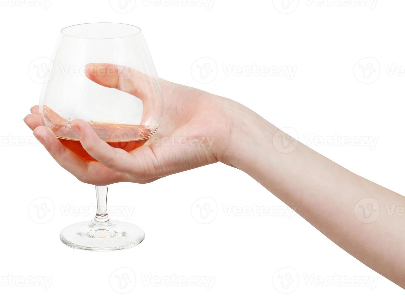 mano detiene bicchiere calice con Brandy foto