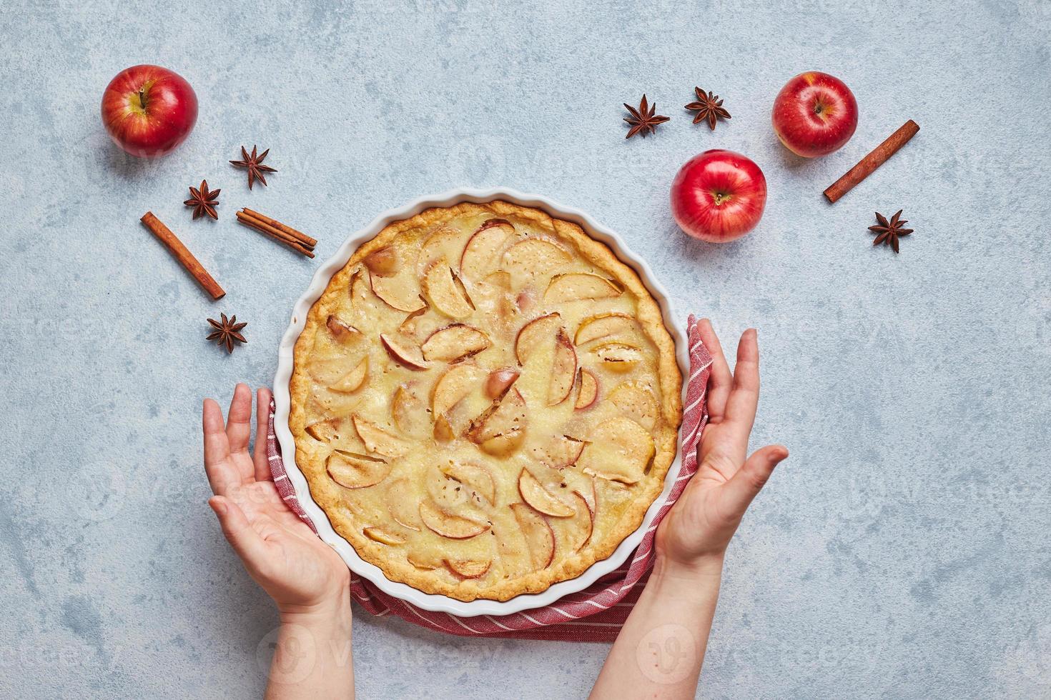 femmina mani e fatti in casa Mela torta con acida crema Riempimento su leggero sfondo, superiore Visualizza. foto