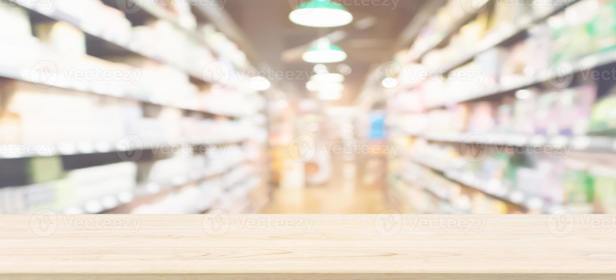 piano del tavolo in legno con sfondo sfocato corridoio del supermercato per la visualizzazione del prodotto foto