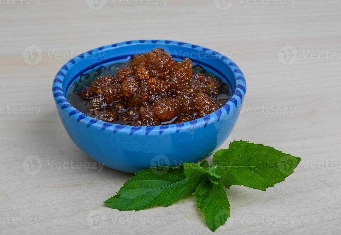 gelso marmellata nel un' ciotola su di legno sfondo foto