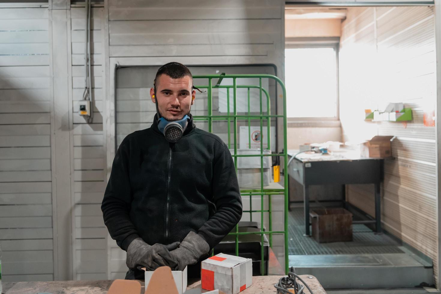 un' uomo Lavorando nel un' fabbrica, indossare un' viso maschera e guanti, Lavorando durante un' coronavirus pandemia foto