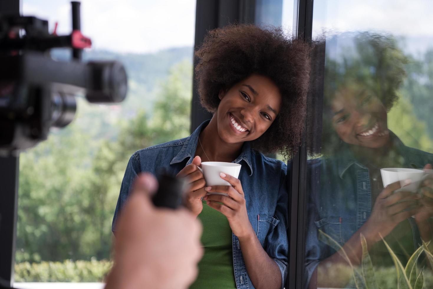 africano americano donna potabile caffè guardare su il finestra foto