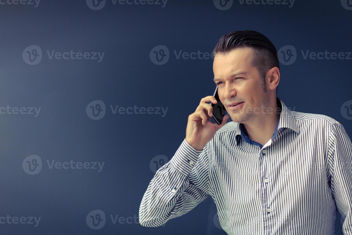 uomo d'affari su il Telefono contro il parete. foto