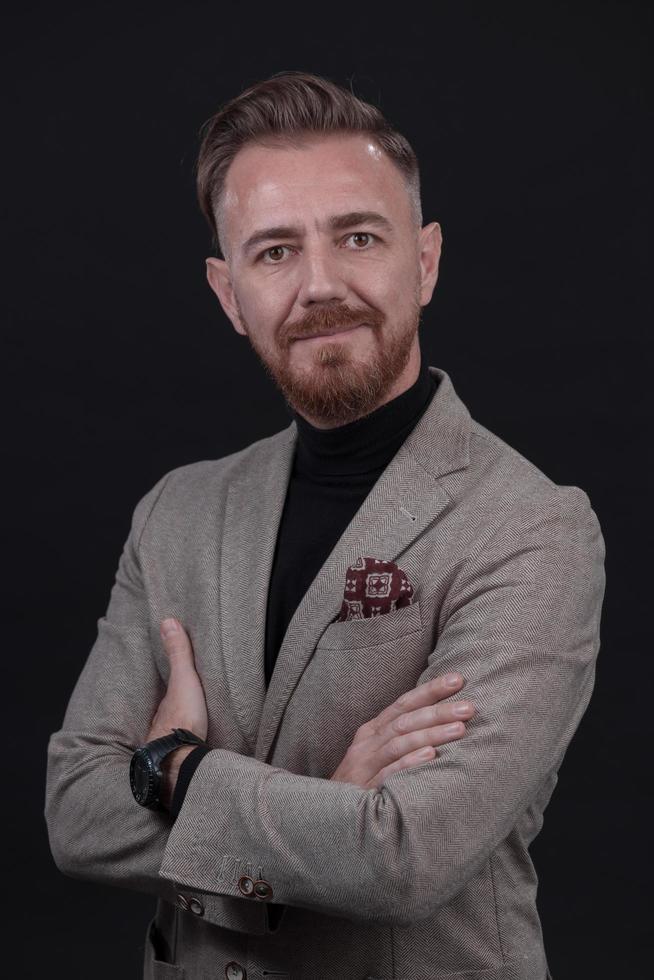 ritratto di un' elegante elegante anziano uomo d'affari con un' barba e casuale attività commerciale Abiti nel foto studio isolato su buio sfondo Esprimere a gesti con mani