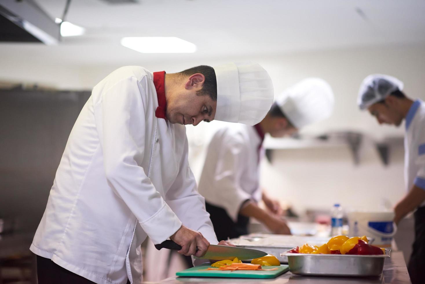 capocuoco nel Hotel cucina fetta verdure con coltello foto