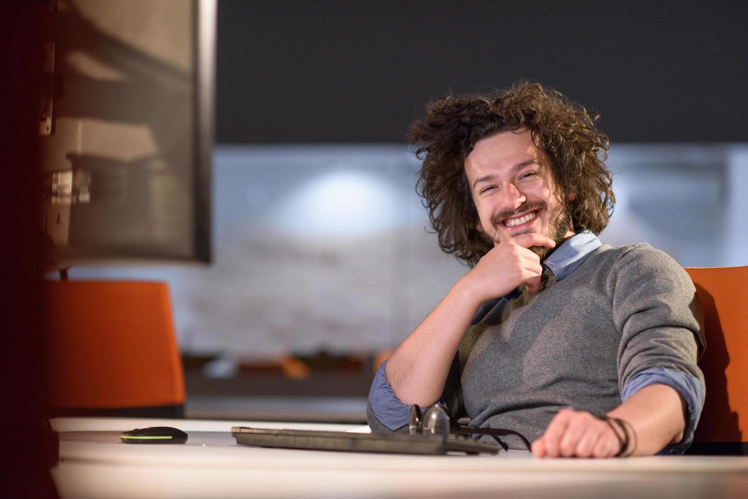 uomo Lavorando su computer nel buio avviare ufficio foto