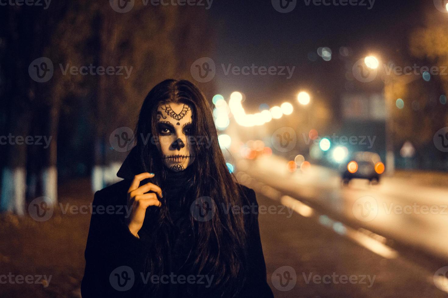 bella donna con trucco del cranio dello zucchero di halloween alla strada foto