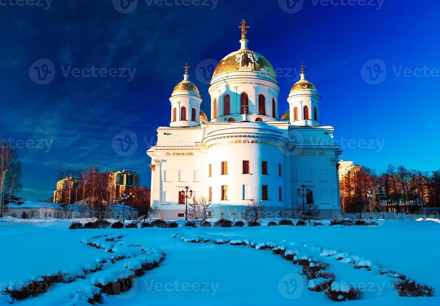 chiesa ortodossa bianca con cupole d'oro contro il cielo invernale blu foto