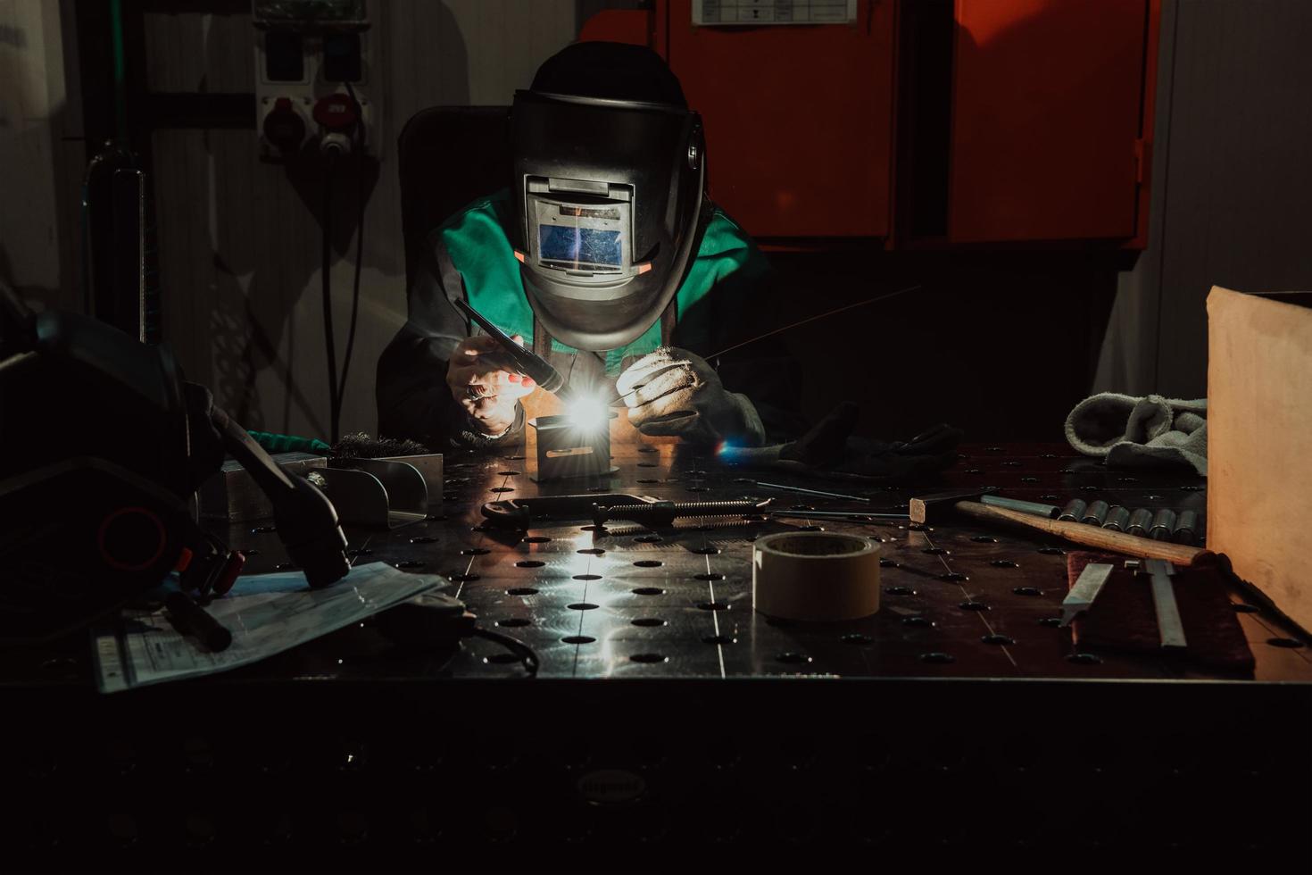 un' donna occupato nel un' moderno fabbrica per il produzione e in lavorazione di metalli nel un' opera uniforme saldatura metallo materiale foto