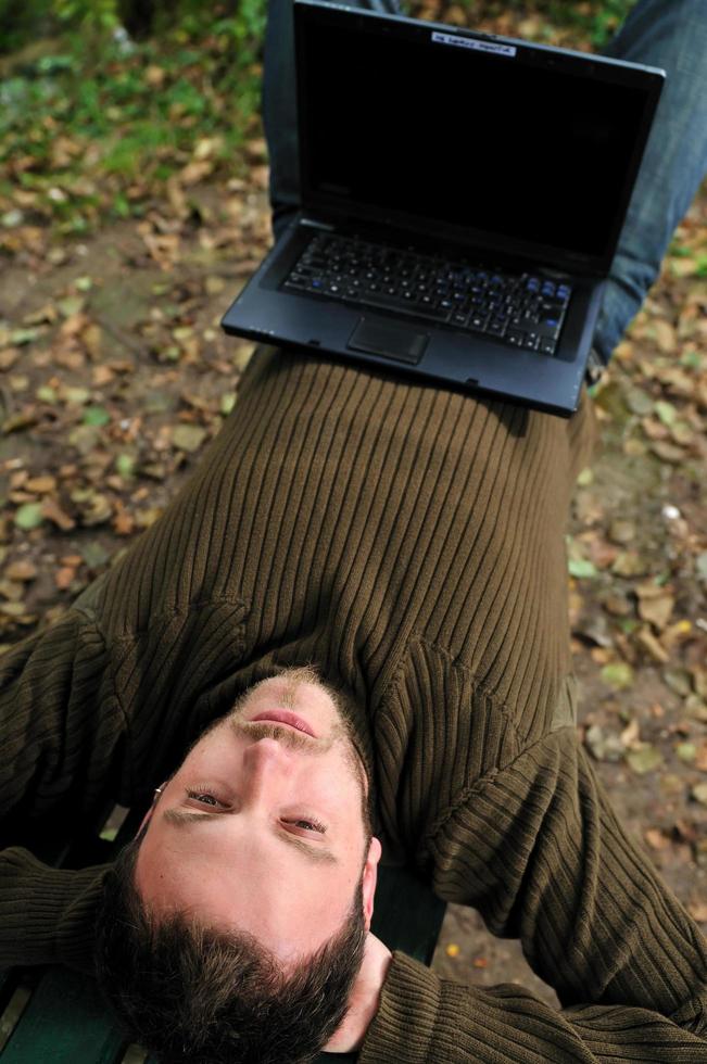 giovane uomo d'affari Lavorando su il computer portatile all'aperto foto