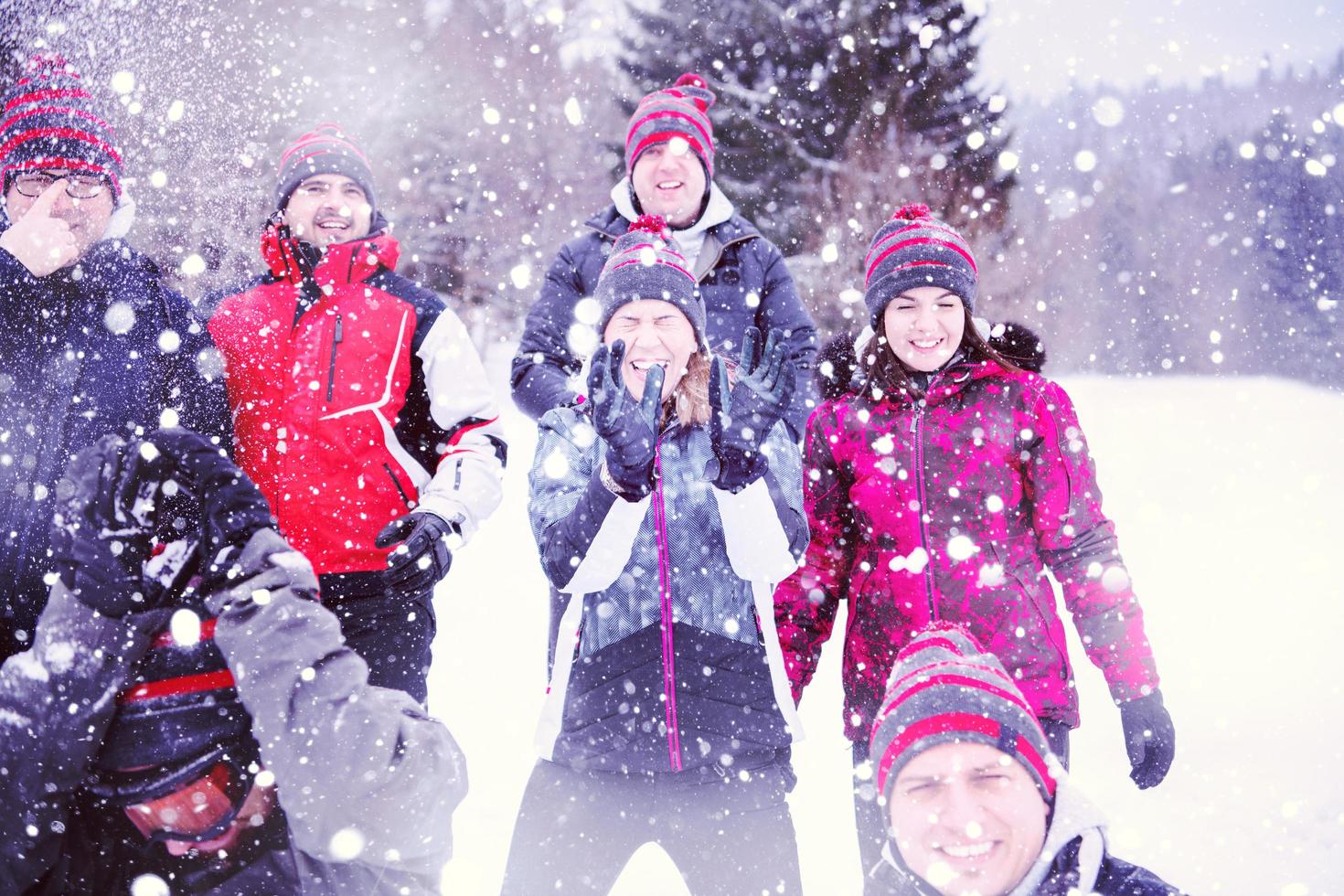 gruppo di giovane persone lancio neve nel il aria foto